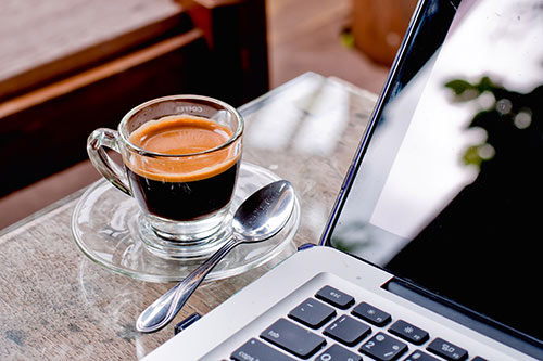 café espresso à côté d'un ordinateur