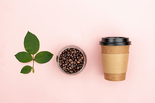Café en grains et gobelet en carton : pause café écolo